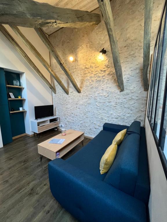 uma sala de estar com um sofá azul e uma mesa em HYPERCENTRE - Entre charme & authenticité - Local vélo em Blois