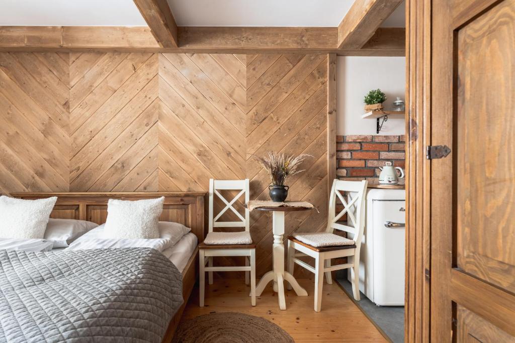 ザコパネにあるGórski klimatのベッドルーム1室(ベッド1台、テーブル、椅子付)