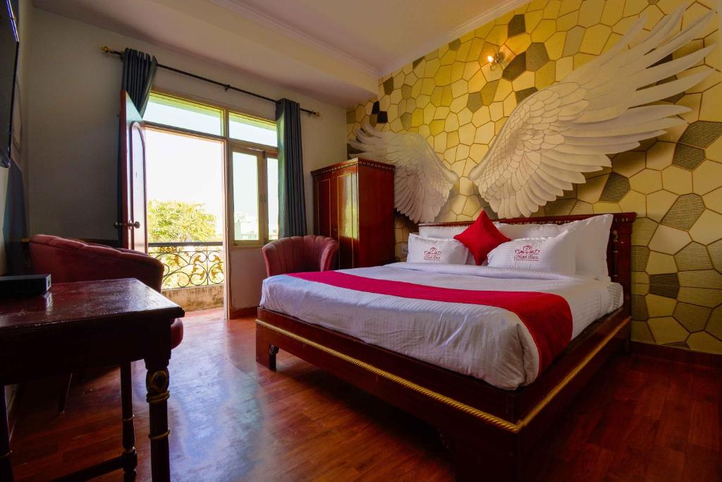 a bedroom with a bed with wings on the wall at Hotel Parv in Jaipur