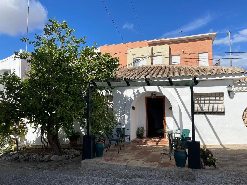 ein weißes Haus mit einem Tisch und Stühlen davor in der Unterkunft Agradable casa con jardín y chimenea interior in Baena
