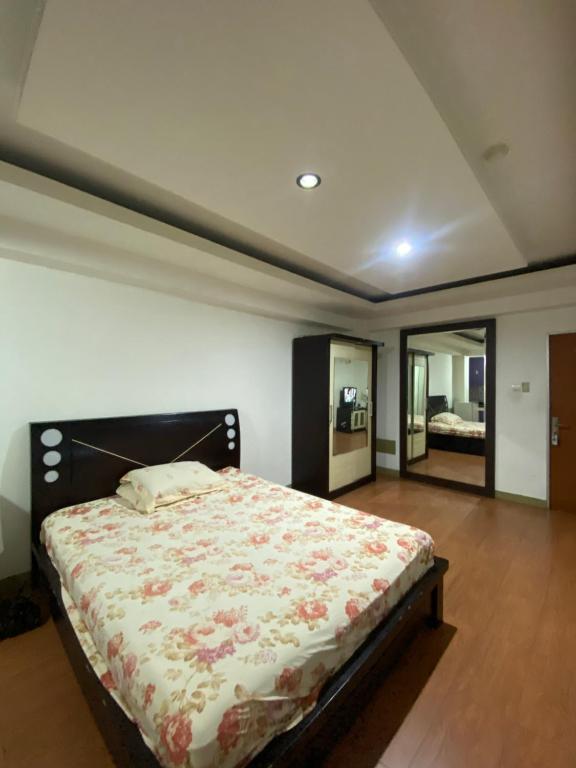 a bedroom with a large bed in a room at Cibubur Village Apartemen by Ar-Ramadhan in Cibubur