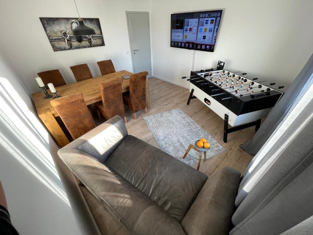 a living room with a couch and a table with a foos ball at MyTimeHouse in Ober-Ramstadt