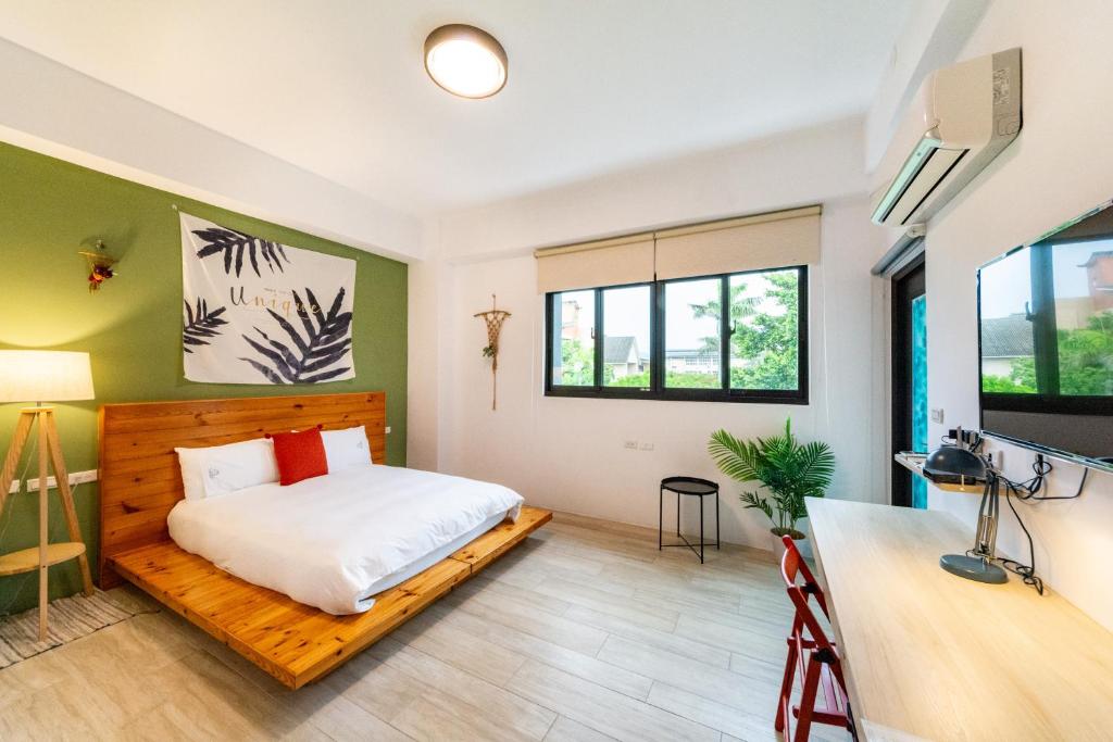 a bedroom with a bed and a desk at 水蛙春 in Hengchun South Gate