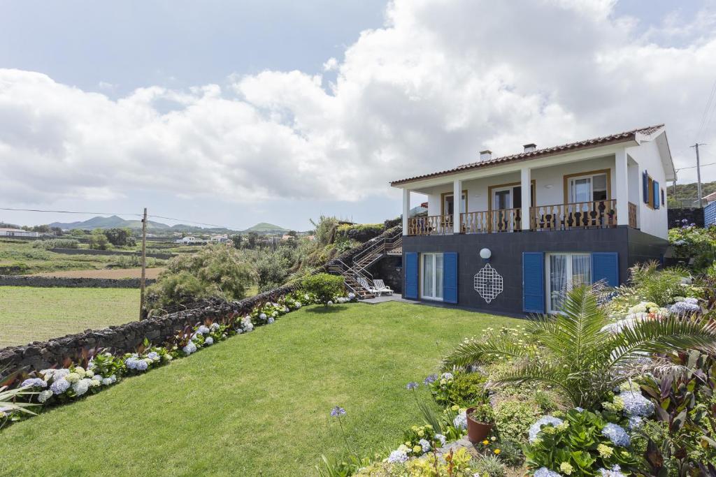 una casa con un jardín delante de ella en Casa Varanda do Mar, en Capelas