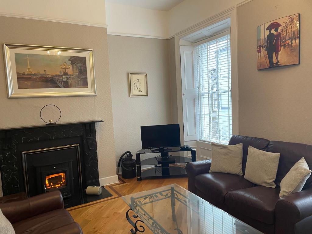 a living room with a couch and a fireplace at Parisian Style Townhouse in Carrick on Shannon
