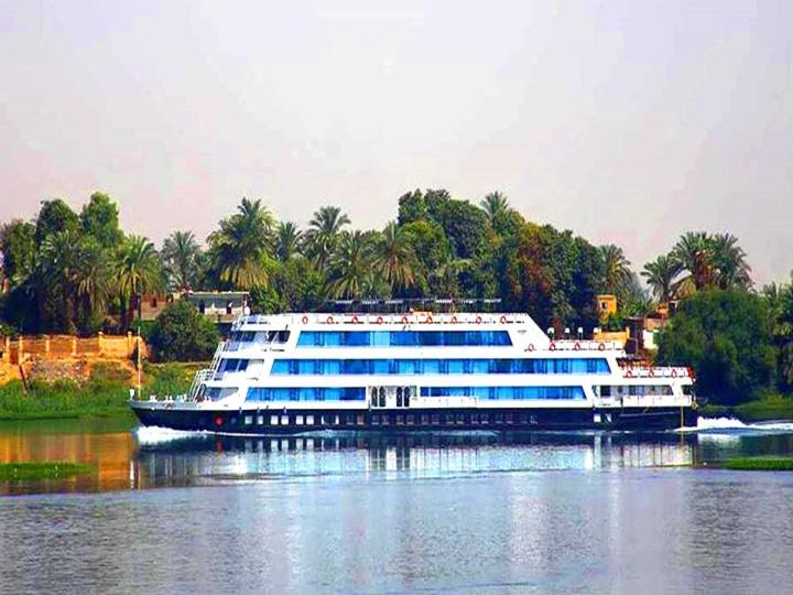 a large boat on a river with trees in the background at Luis Luxor Nile Cruise in Luxor