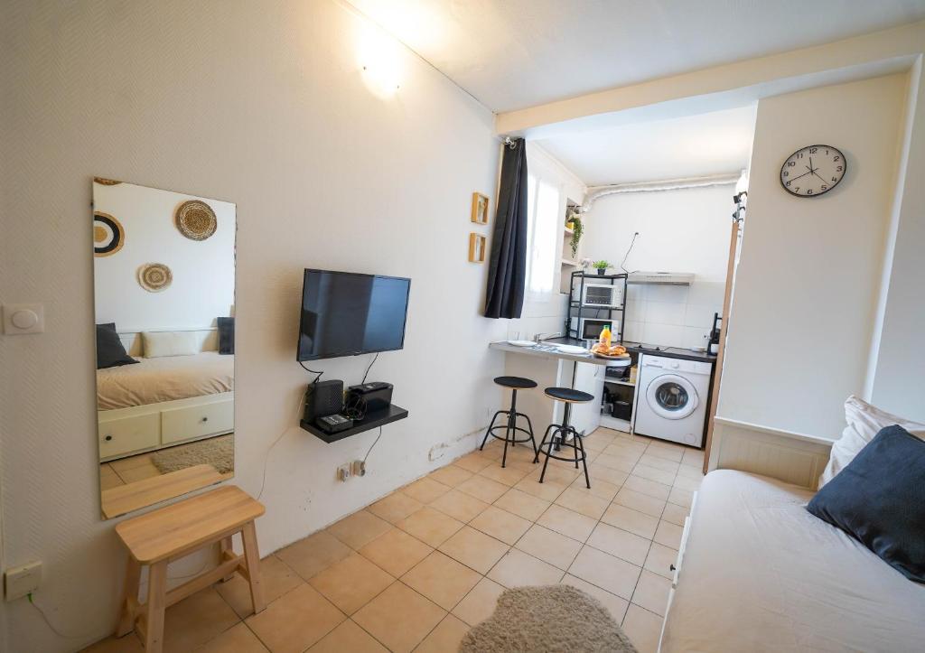 une chambre avec un lit et une cuisine avec un four micro-ondes dans l'établissement Studio le Petit Pantin - Cozy nest, à Pantin