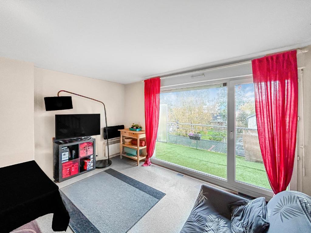 a living room with a large window with red curtains at SeaHaven in Saint-Brieuc