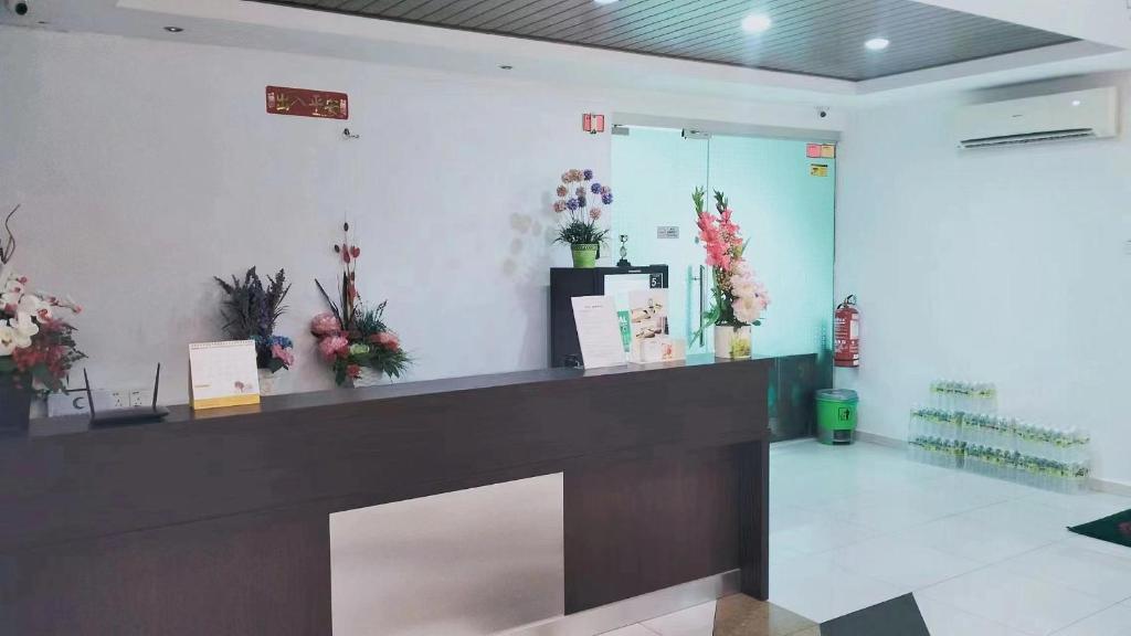 uma floricultura com um balcão com flores na parede em FLG Motel em Alor Setar