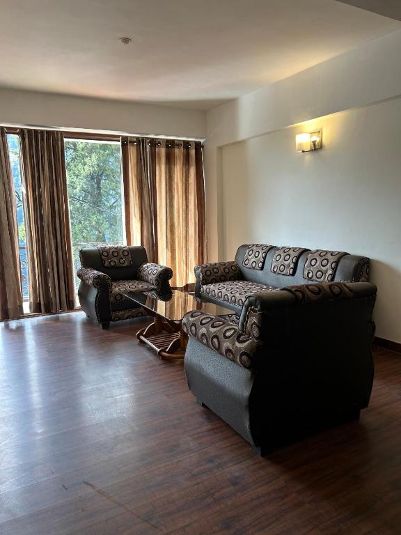 a living room with two couches and a table at Panoramic View of Lake close to Mall Road - Oasis in Nainital