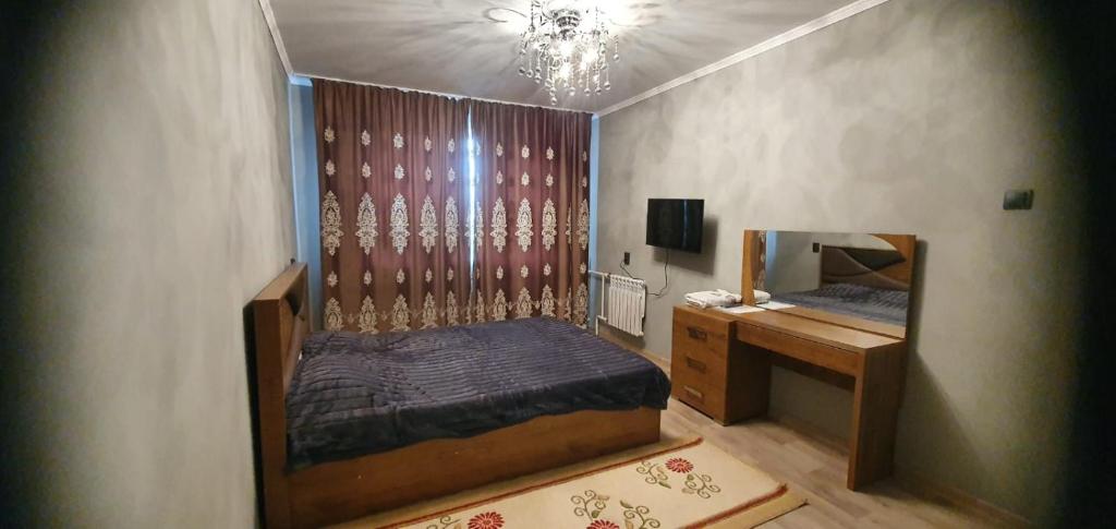 a bedroom with a bed and a desk and a mirror at 1 комнатная квартира в Павлодаре in Pavlodar