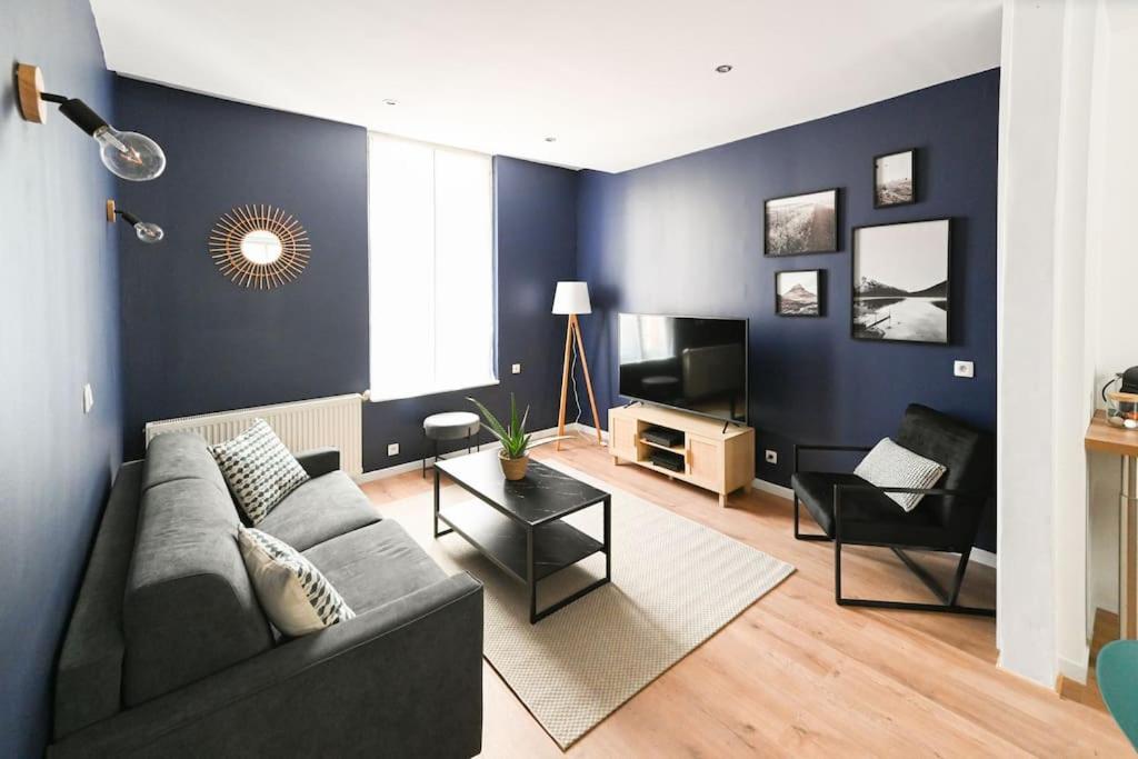 ein Wohnzimmer mit einem Sofa und einem TV in der Unterkunft Downtown LH - Confort - 6 pers in Le Havre