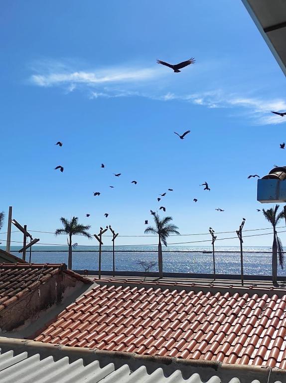 a view of the beach with birds flying in the sky at Apartamento na Passarela in Porto Seguro