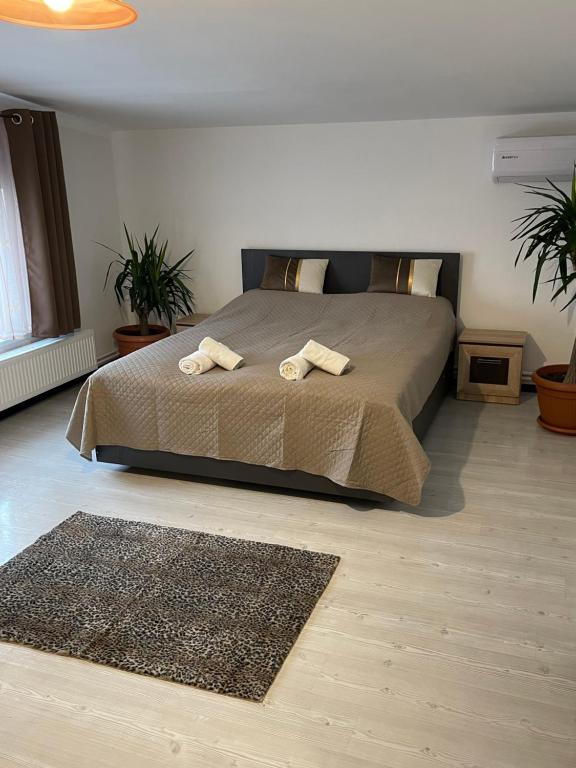 a bedroom with a bed with two towels on it at White&Red Apartments in Timişoara