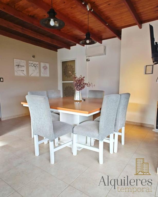 a dining room with a wooden table and chairs at Firmat Apart Premium Estadías confortables para empresas y familias in Firmat