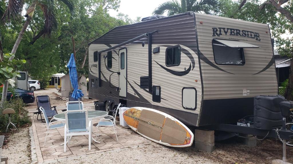 an rv with a surfboard sitting on a patio at Tiny House RV, Kayak in Key Largo