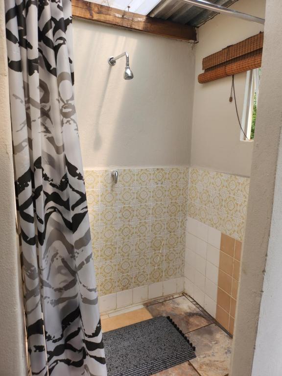 a bathroom with a shower with a shower curtain at Merry Mongoose Riverside Tent in Skeerpoort