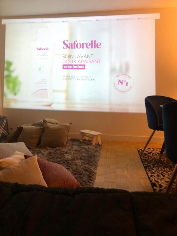 a large screen with a presentation in a living room at Habitation Salomé in Paris