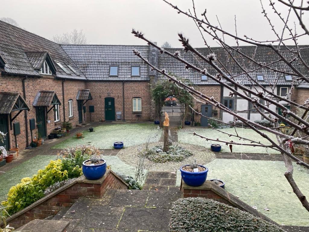 a courtyard of a house with blue pots in it at The Old Sack Warehouse in Hereford