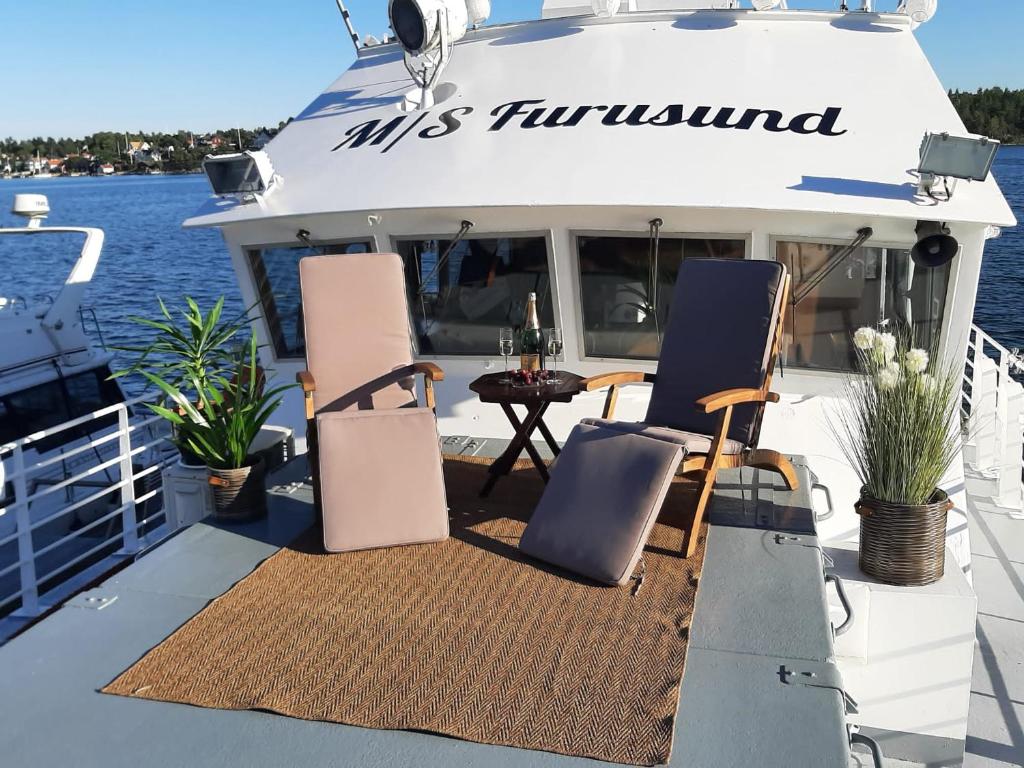 einen Tisch und Stühle auf der Rückseite eines Bootes in der Unterkunft M/S Furusund in Furusund
