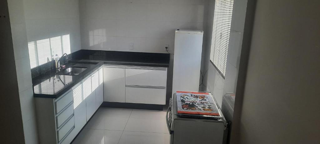 a small kitchen with a sink and a refrigerator at VS HOSPEDAGEM in Cascavel