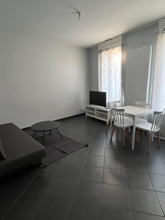 a living room with a table and chairs and a couch at Appartement gare RER D maisons alfort Alfortville in Alfortville