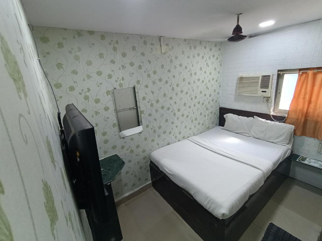 - une petite chambre avec un lit et une télévision dans l'établissement Hotel OVO Residency Near Masjid Bunder Railway Station, à Mumbai