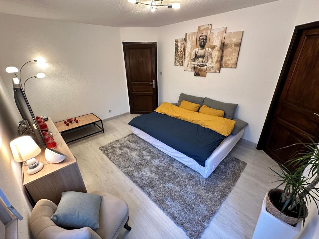 ein Schlafzimmer mit einem Bett, einem Sofa und einem Stuhl in der Unterkunft Superbe F2 terrasse, route du vin, Florival in Guebwiller