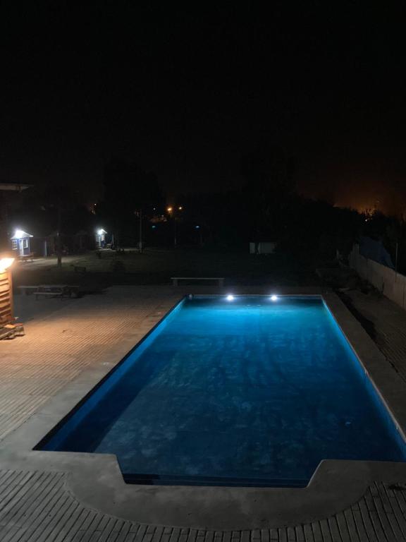 una piscina azul por la noche en Cabañas San Carlos, en Las Cruces