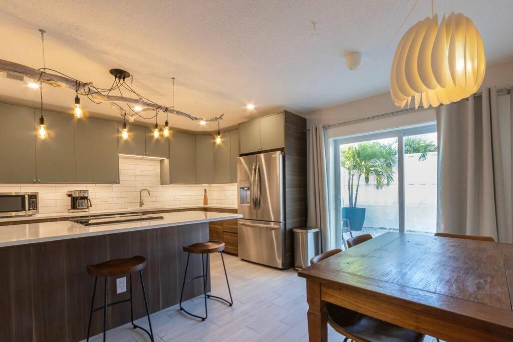 cocina con mesa de madera y comedor en NEW! Stylish & Cozy Sea Grape near Beach & Flagler en New Smyrna Beach