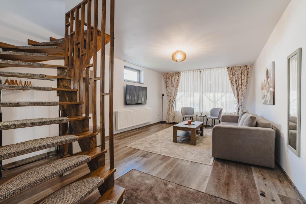 a living room with a spiral staircase and a couch at Cazare Zorilor in Zărneşti