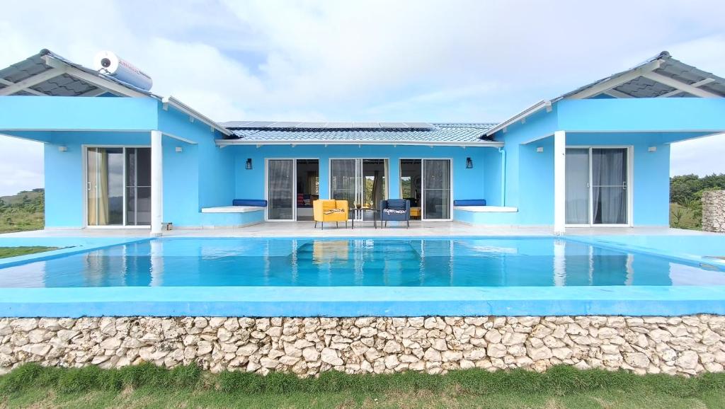 una casa azul con piscina frente a ella en Finca Jasmat, en Cabrera