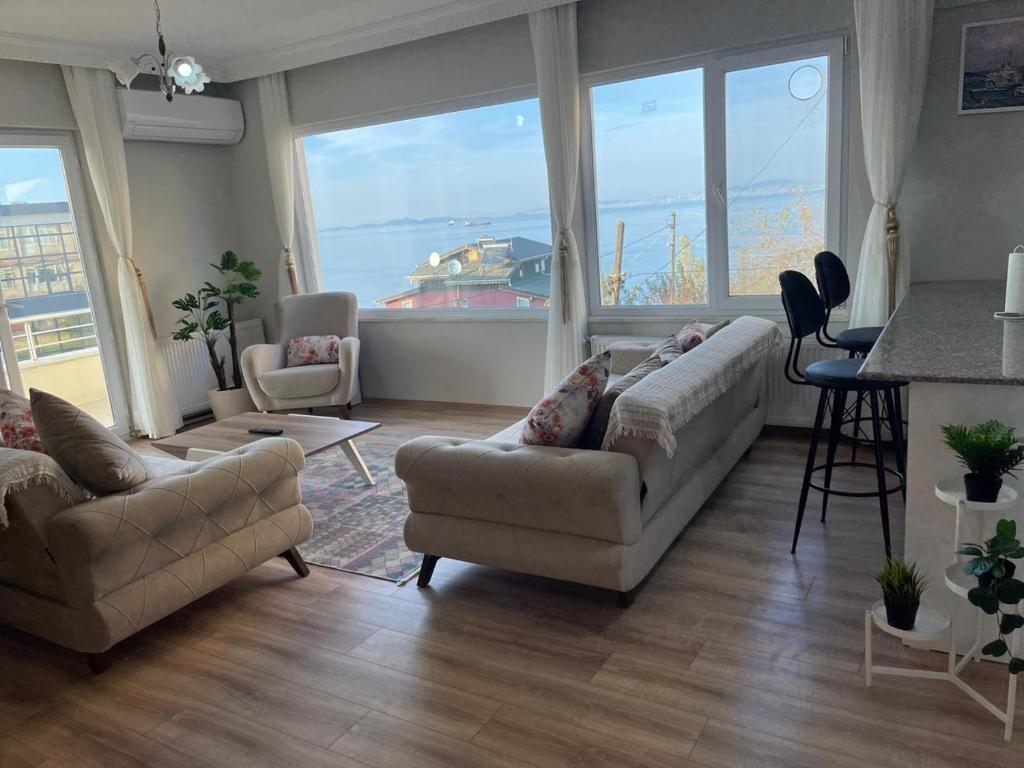 uma sala de estar com 2 sofás e uma cozinha com vista para um barco em Yalova Apartments em Yalova