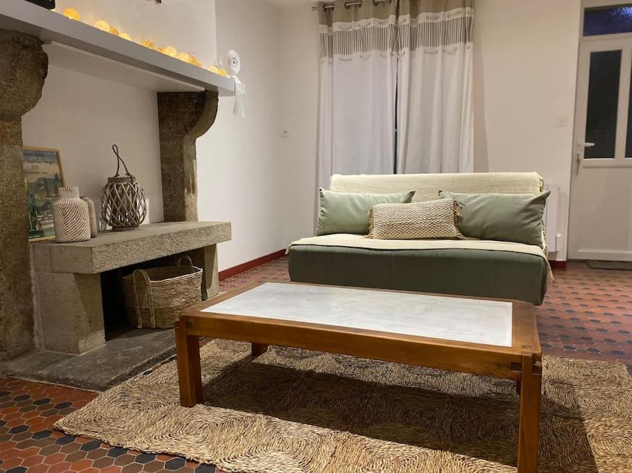 a living room with a couch and a coffee table at La petite maison de Coline in Réville