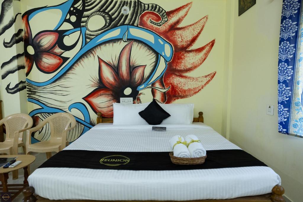sypialnia z łóżkiem z obrazem na ścianie w obiekcie Reunion Amity w mieście Udupi
