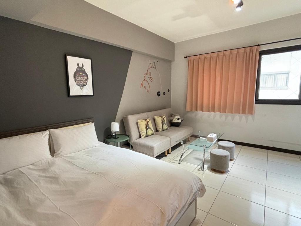 - une chambre avec un lit blanc et un canapé dans l'établissement Yi Chung Disney, à Taichung