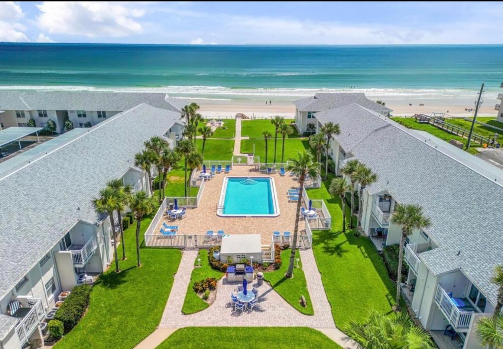 an aerial view of a pool and the beach at Beachfront Serenity Private Balcony with Ocean View, Shared Heated Pool and BBQ in New Smyrna Beach