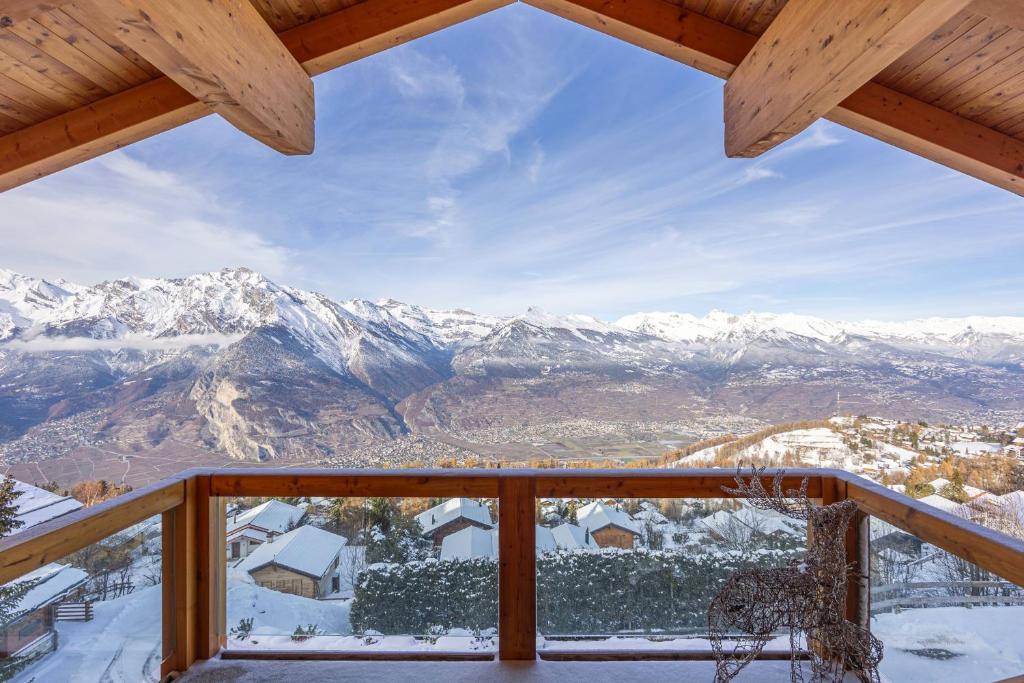 a view from the balcony of a cabin with snow covered mountains at Ciel Etoilé - Magnifique Chalet, 14 personnes - vue incroyable in Nendaz
