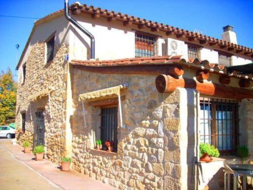 a stone building with a window on a street at La Tellería in Valjunquera