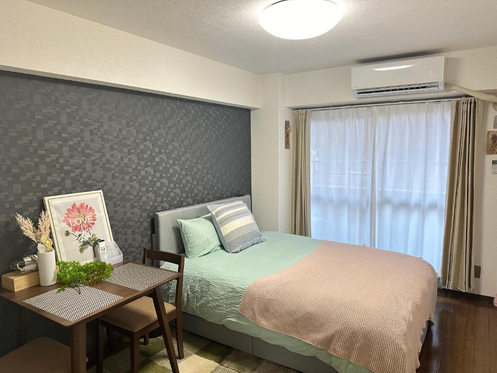 um quarto com uma cama, uma mesa e uma janela em 新宿歌舞伎町步行新宿市中心免费Wi-Fi08 em Tóquio