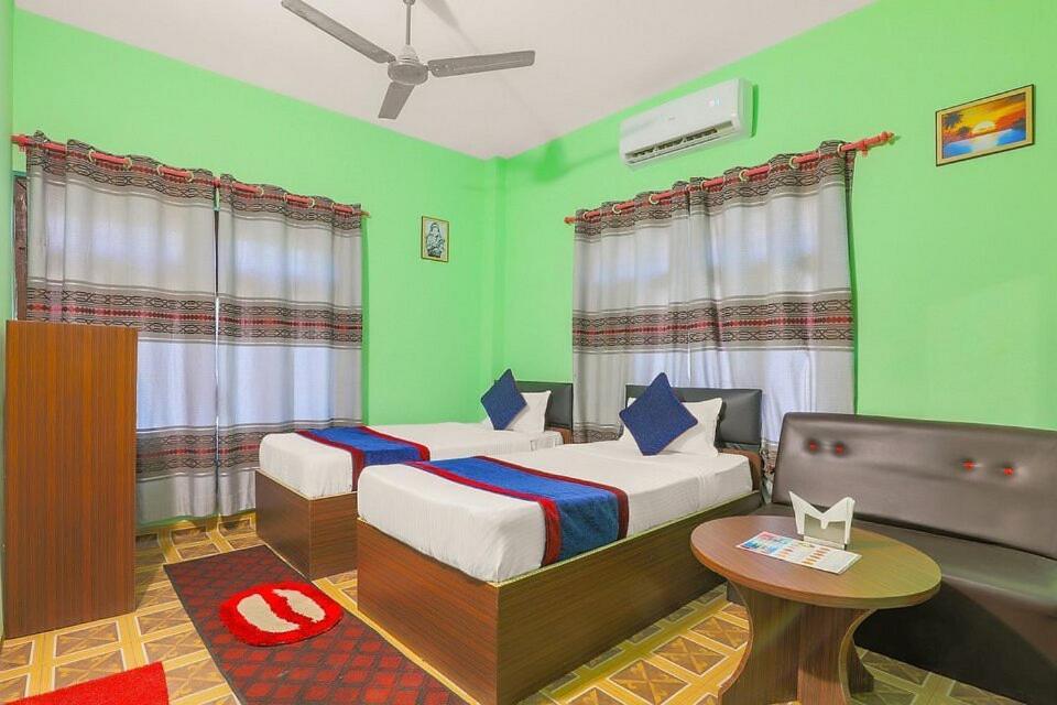 una camera con due letti in una stanza con pareti verdi di Namaste Hotel a Ataria