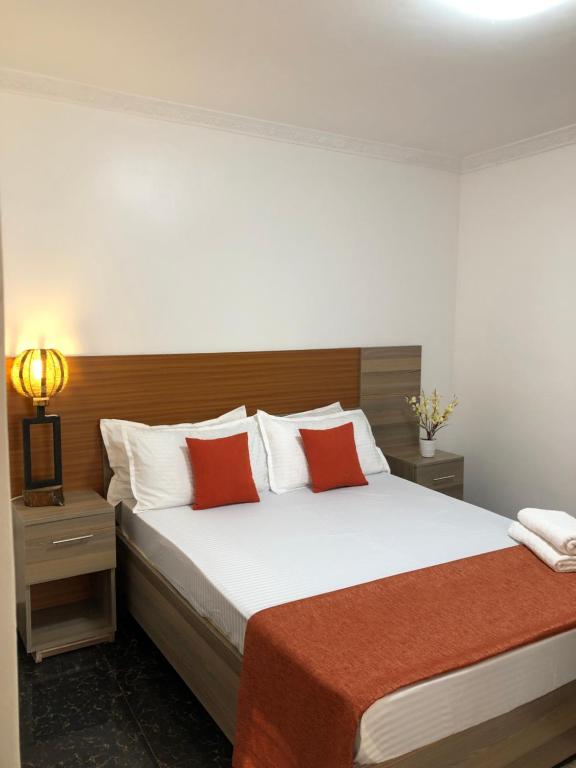 1 dormitorio con 1 cama grande con almohadas rojas en Savwa Resort and Gardens, en Kakamega