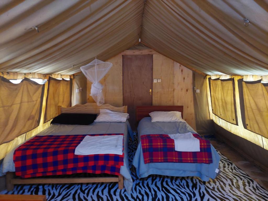 a couple of beds in a tent at KANUNKA HOUSE in Sekenani