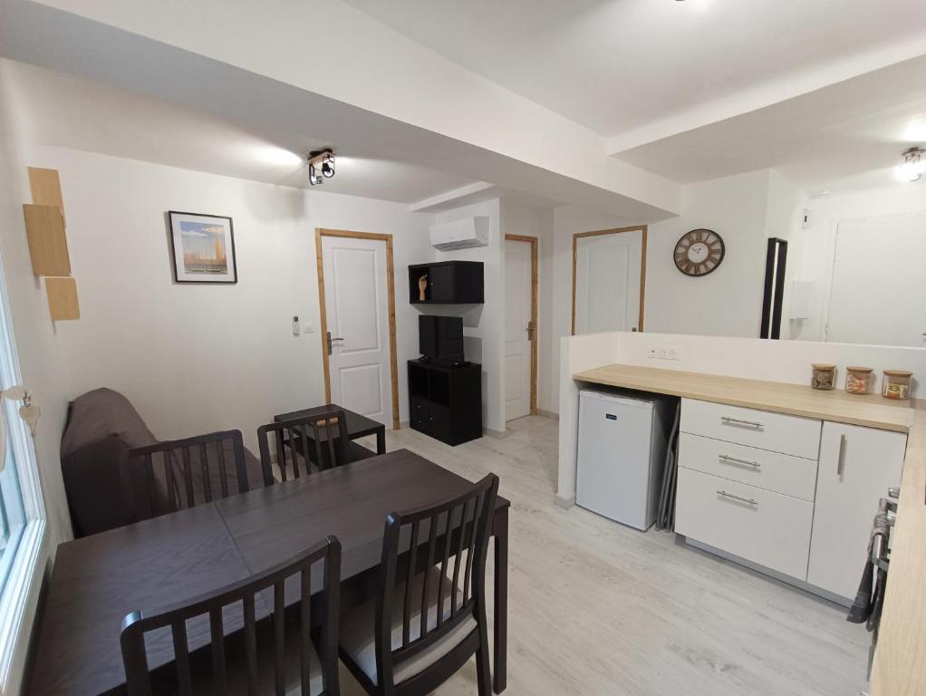 une cuisine et une salle à manger avec une table et des chaises dans l'établissement T3 cosy climatisé, intra-muros Avignon, à Avignon