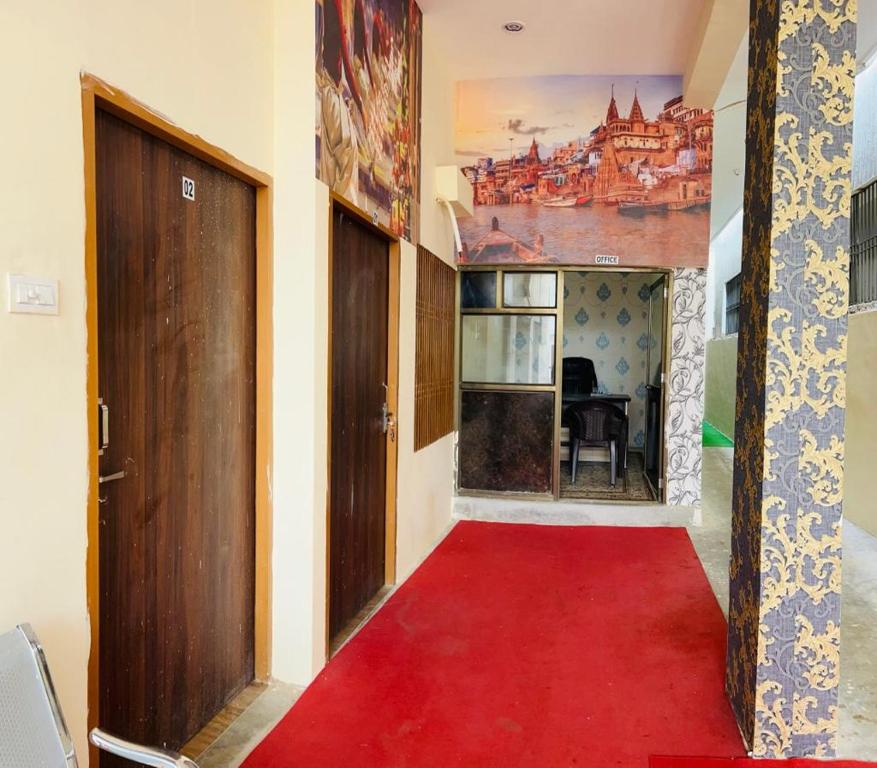 a red carpet in a hallway with a door at RN Residency in Varanasi