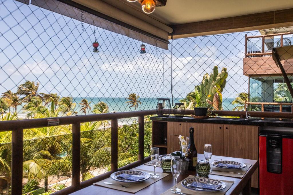 Cumbuco Wai Wai Apartamento com vista para o mar في كومبوكو: شرفة مع طاولة وإطلالة على المحيط