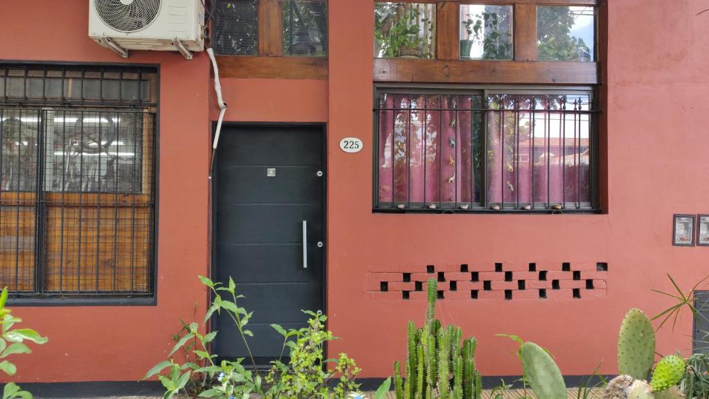 a house with a black door and windows at Bicicleteria Don Perez in San Isidro