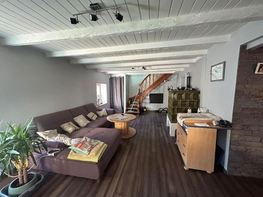een woonkamer met een bank en een tafel bij Agréable maison familiale in Mitzach