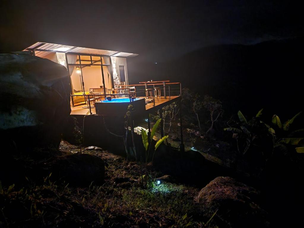 uma pequena casa com uma banheira azul no escuro em El eden hotel Boutique em Sasaima