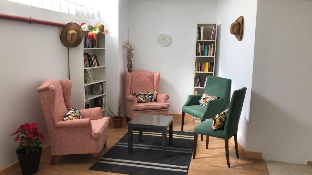 una stanza con sedie, tavolo e librerie di Urban rest zone and coworking ad Arrecife